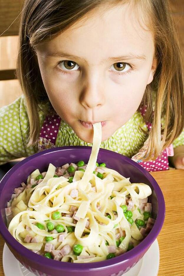 Una niña comiendo un plato de pasta./gtres