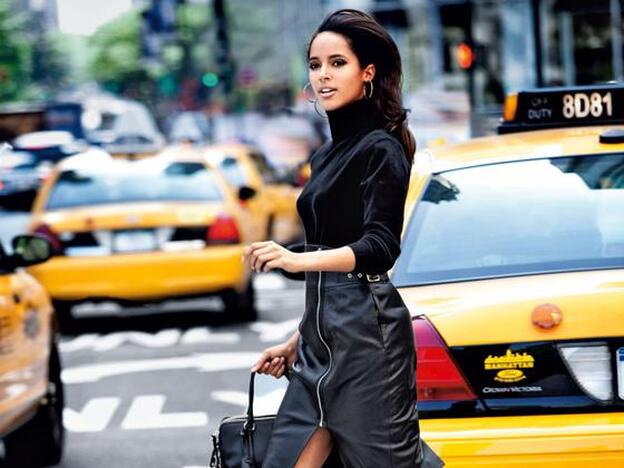 Chica cruzando la calle entre taxis./getty