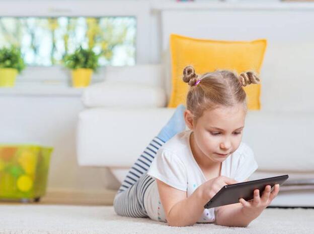 Una niña jugando con una tableta./fotolia