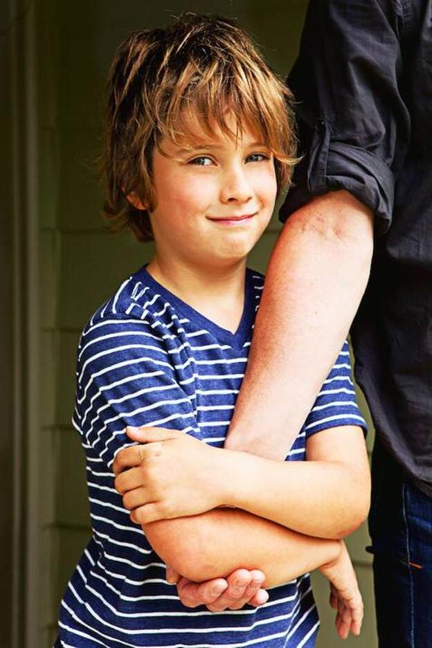 Un niño agarrando del brazo a su padre/getty