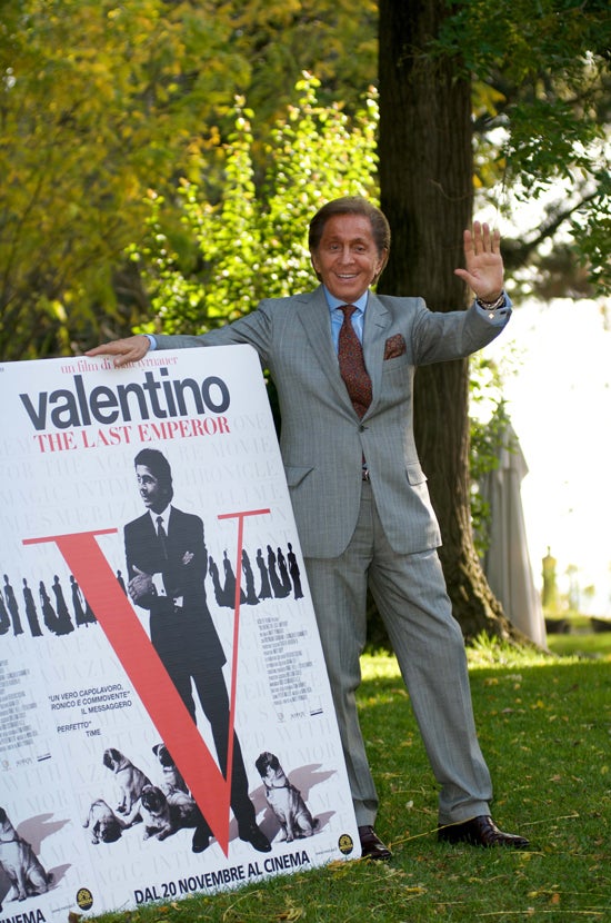 Valentino en junto con el cartel de Valentino: the ast emperor