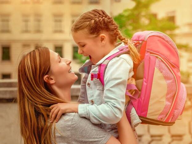 Una madre llevando a su hija a la escuela./adobe stock