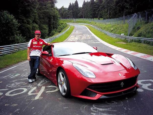 Fernando Alonso junto a su Ferrary rojo.