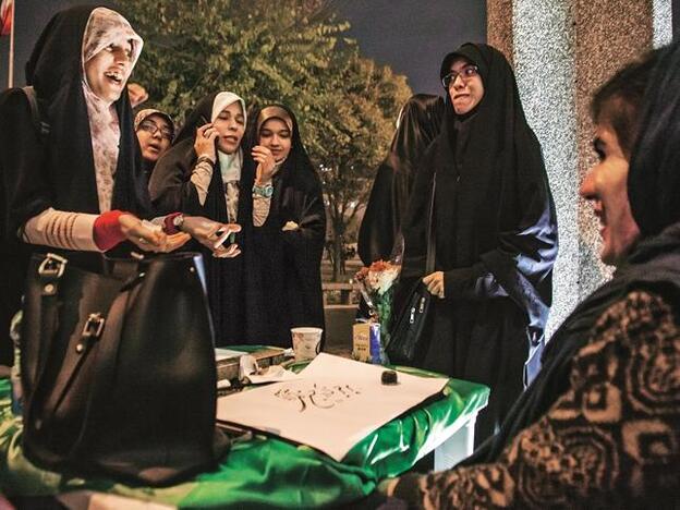 Mujeres practicantes del Islam hablan con la profesora de caligrafía persa en un whorkshop organizado en conmemoración del cumpleaños de Mahoma.