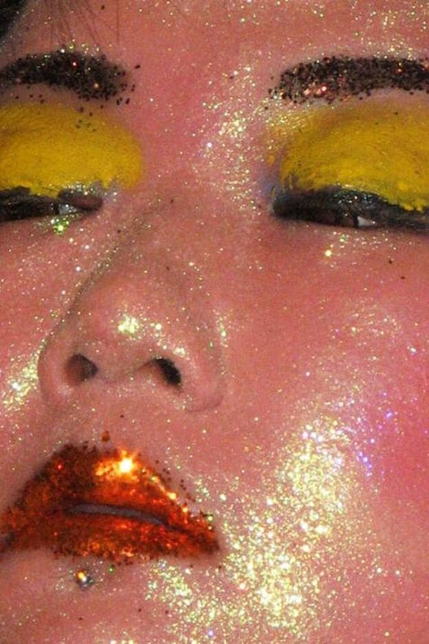 Sobredosis de purpurina y sombra amarilla en este maquillaje totalmente experimental.