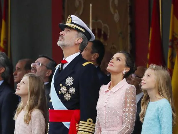 La Familia Real, muy atentos al paracaidista durante el desfile militar. Pincha sobre la imagen y descubre los mejores estilismos de la Reina en el Día de la Hispanidad./gtres