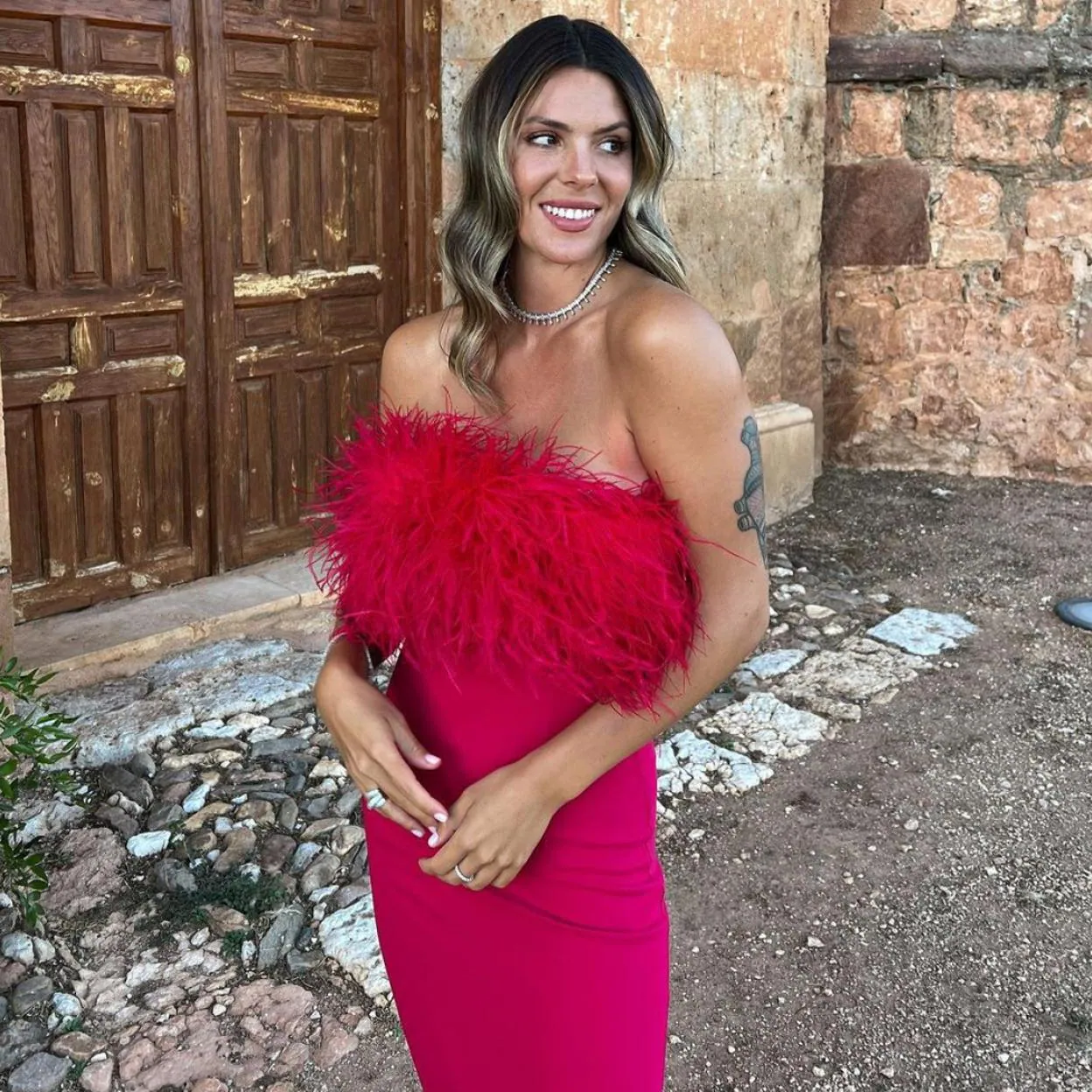 Laura Matamoros demuestra que el vestido de invitada perfecto lleva un  escote precioso y unas plumas de colores