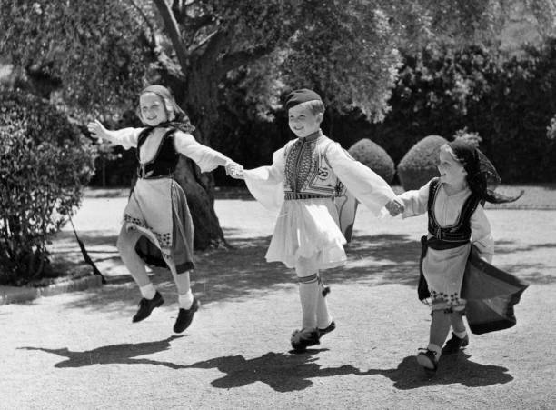 La reina Sofía, primera por la izquierda, vestida con el traje tradiciona griego durante su infancia, junto a sus hermanos Constantino e Irene. 