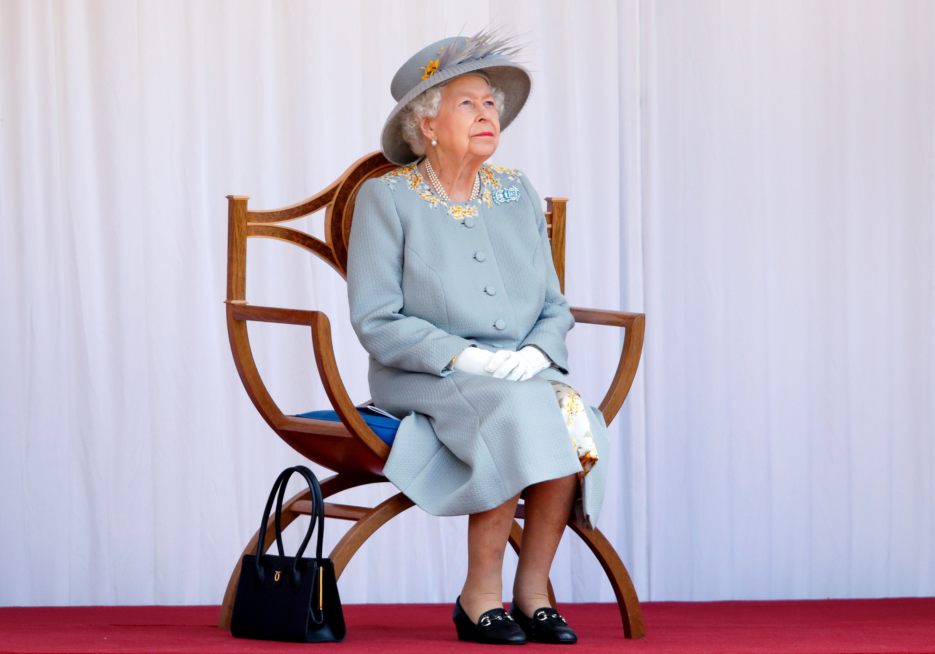 WINDSOR, UNITED KINGDOM - JUNE 12: (EMBARGOED FOR PUBLICATION IN UK NEWSPAPERS UNTIL 24 HOURS AFTER CREATE DATE AND TIME) Queen Elizabeth II watches a flypast by the RAF Red Arrows as she attends a military parade, held by the Household Division (during which The Queen's Colour of F Company Scots Guards will be trooped) in the Quadrangle of Windsor Castle, to mark her Official Birthday on June 12, 2021 in Windsor, England. For the second consecutive year The Queen's Birthday Parade, known as Trooping the Colour, hasn't been able to go ahead in it's traditional form at Buckingham Palace and Horse Guards Parade due to the ongoing COVID-19 Pandemic. (Photo by Max Mumby/Indigo - Pool/Getty Images)/