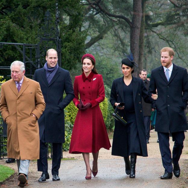 Carlos III, el príncipe Guillermo, Kate Middleton, Meghan Markle y Harry pasean por un parque.