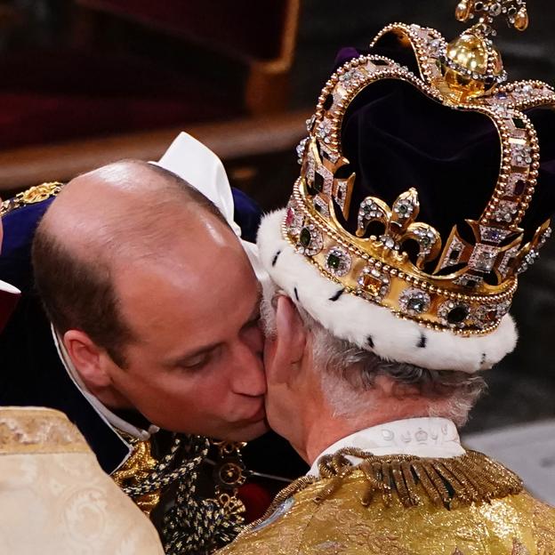El príncipe Guillermo besa a su padre, el rey Carlos III tras su coronación 