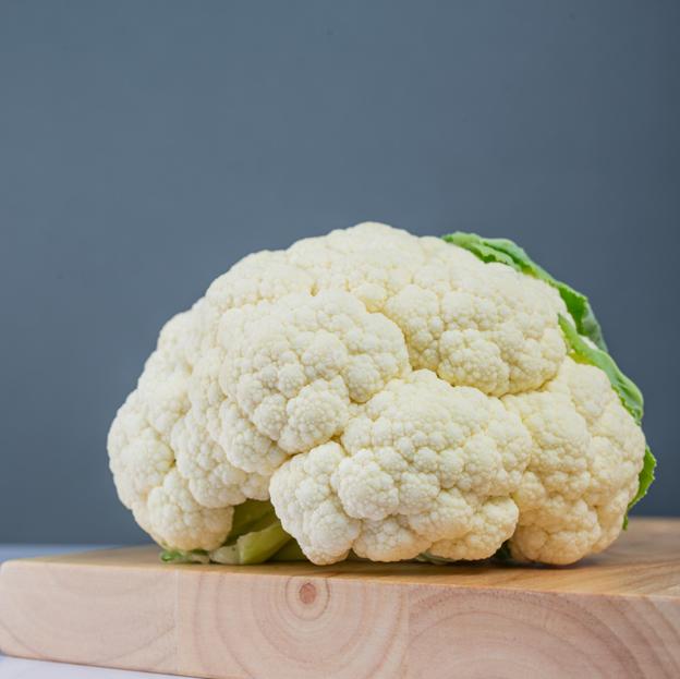 Coliflor sobre una tabla de madera. 