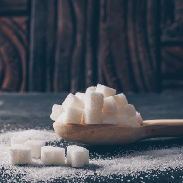 Terrones de azúcar blanca sobre una cuchara. 