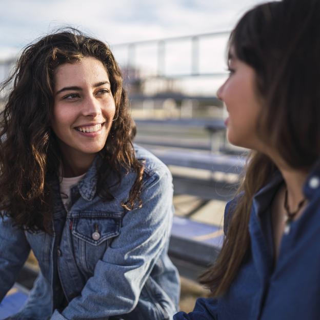 Dos mujeres hablando en un parque. 