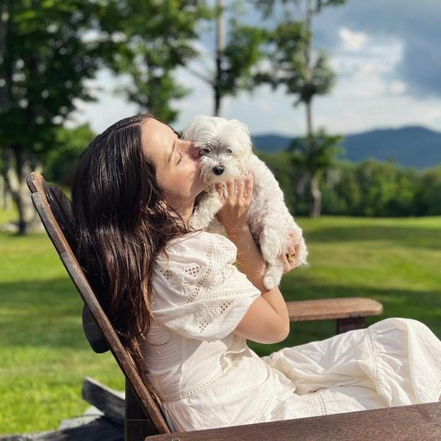 Ana de Armas junto a su perro con un vestido blanco.