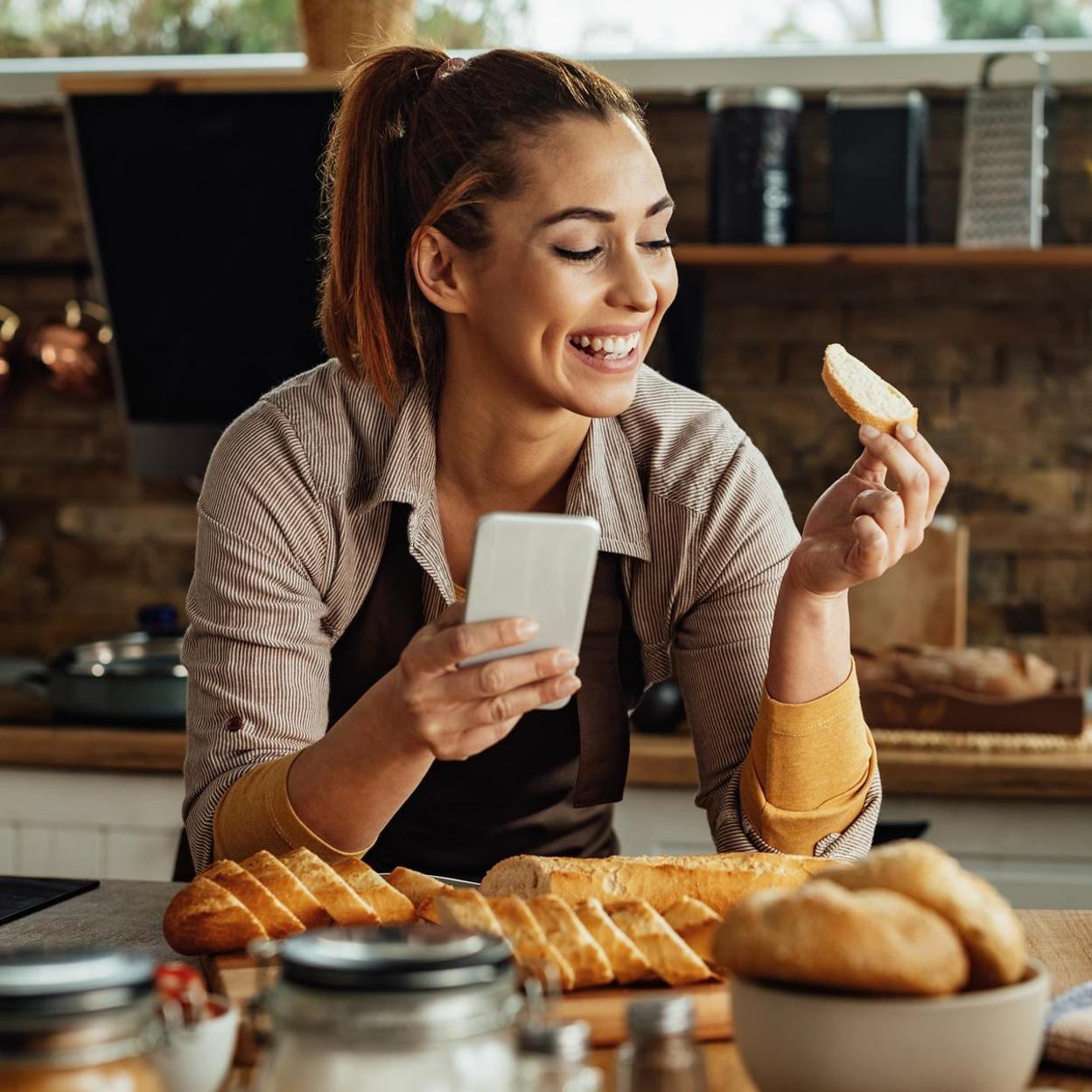 Mujer preparando tostadas en la cocina. /Imagen de Drazen Zigic en Freepik.