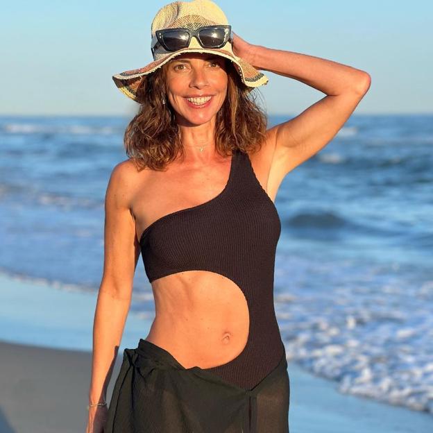 La actriz Maribel Verdú con un trikini negro posando frente a la cámara en una playa mexicana. 