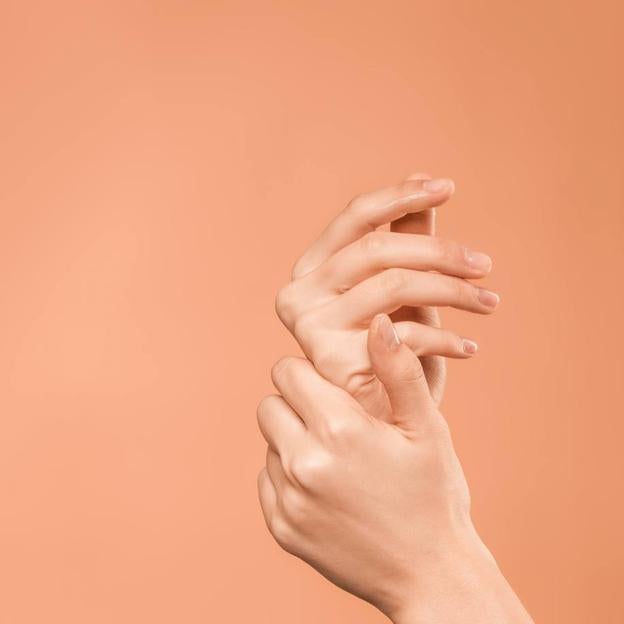 Mujer usando crema exfoliante de manos