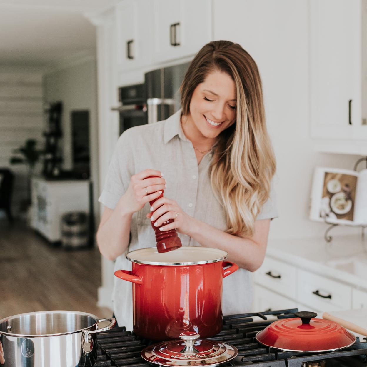 Mujer feliz cocinando con alimentos sanos/unplash