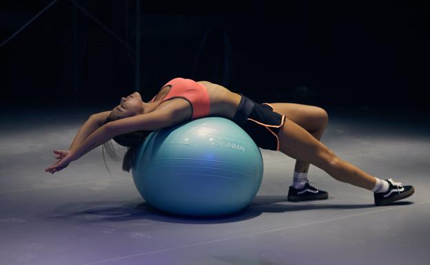 Mujer haciendo ejercicio con pelota. /