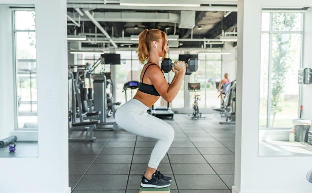 Mujer haciendo ejercicio con mancuernas. /