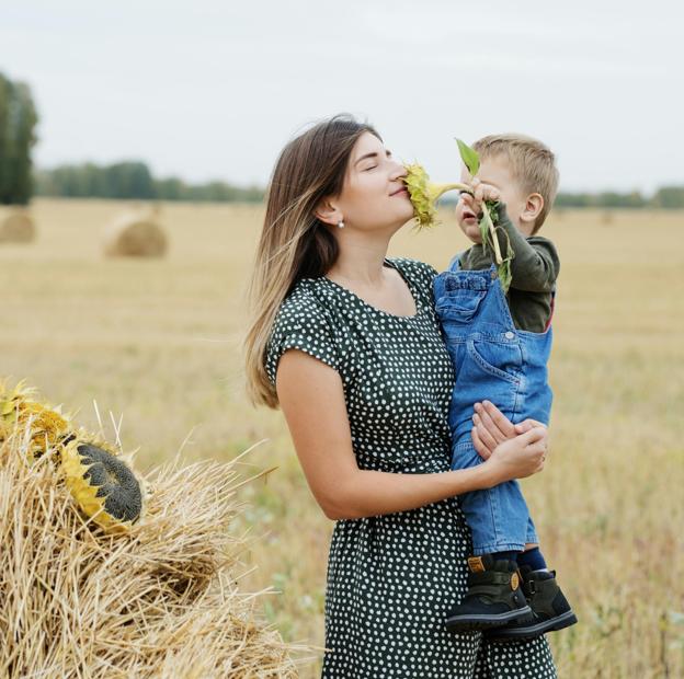 Mujer disfrutando de la naturaleza con su hijo.