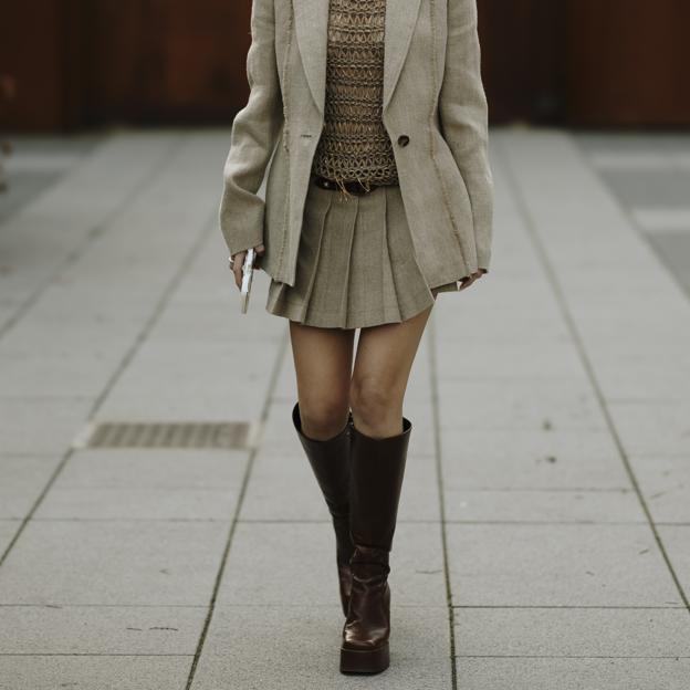 Un look de street style con falda mini y botas altas.