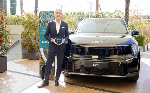 Emilio Herrera posa con el premio junto al KIA EV9.