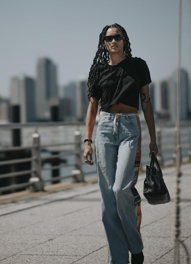 Look de camiseta negra con vaqueros especiales.