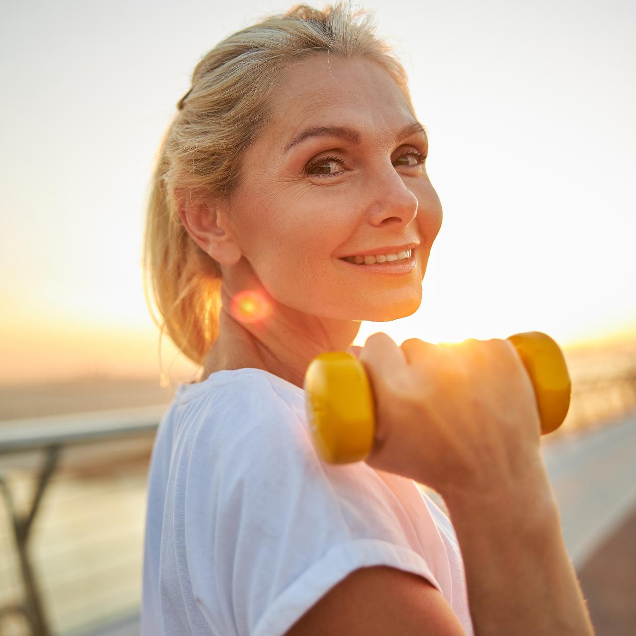 Mujer con ropa deportiva en la playa. /istock