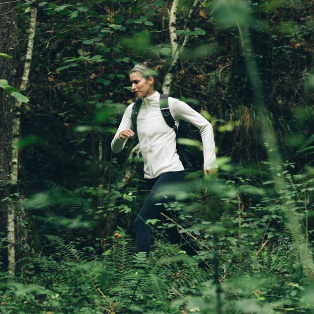 Mujer corriendo en un bosque. 