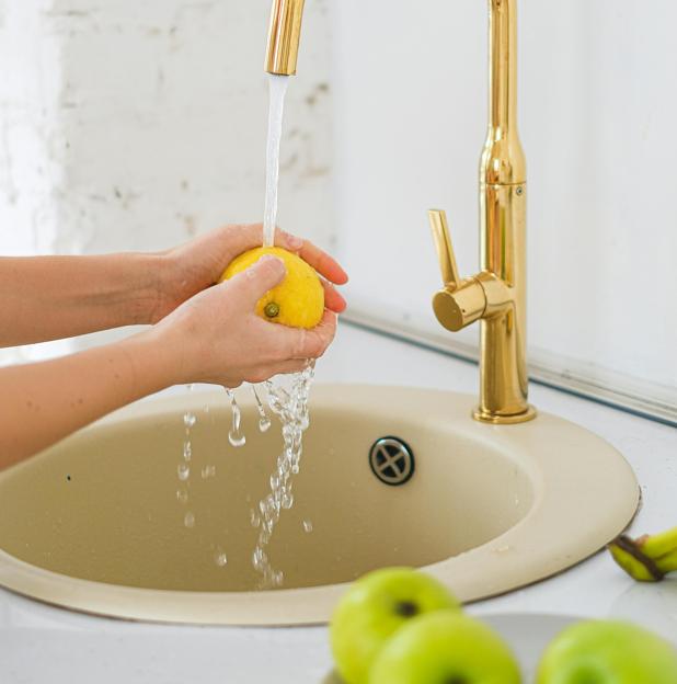 Mujer lavando manzanas verdes. 