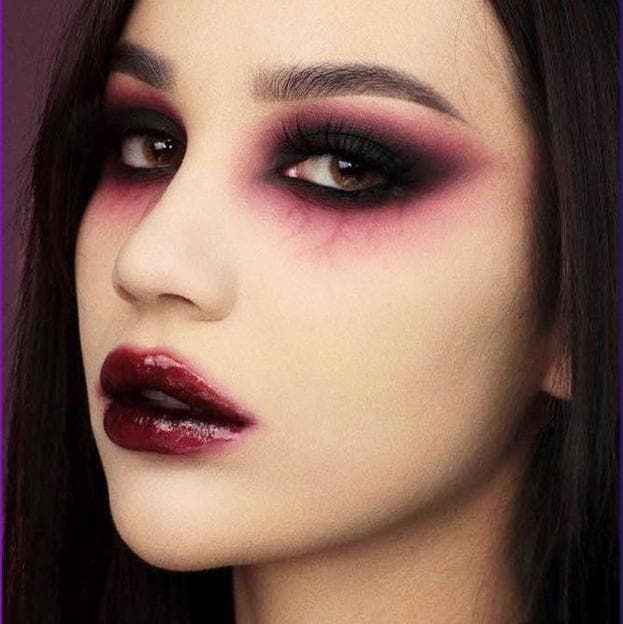 Maquillaje de vampiresa para Halloween en tonos burdeos con venas marcadas en los ojos