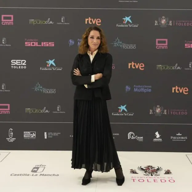 Ana Belén con un total look negro con falda plisada.