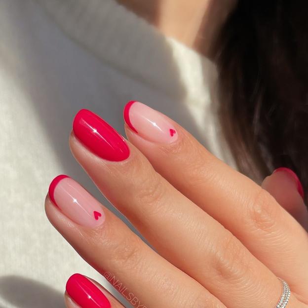 Uñas rojo cereza con manicura francesa y dibujos de corazones