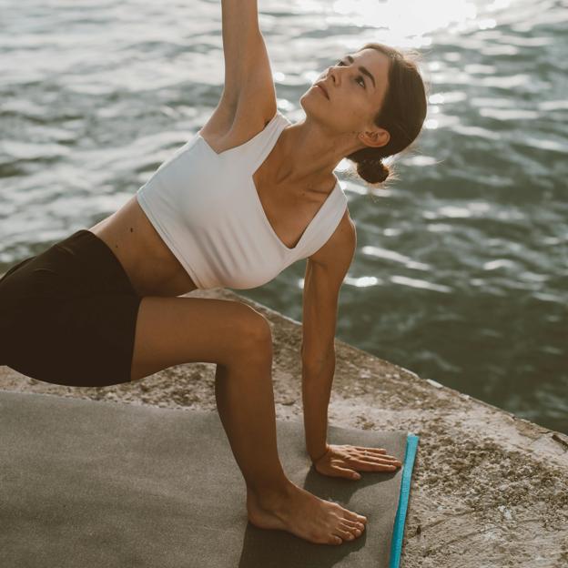 Mujer practicando yoga al aire libre. 