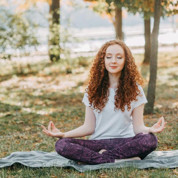 Mujer practicando yoga al aire libre. 